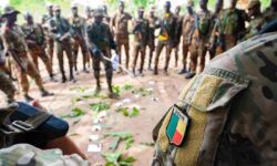 A platoon lieutenant from Benin engages in a training exercise to combat civil threats, discussing tasks using a sand table diagram.